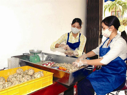 Hai sinh viên trường Cao đẳng Lưu trữ Trung ương được chủ cửa hàng thuê làm nhân bánh Trung thu. Họ chỉ mang găng tay khi... có đoàn kiểm tra. Ảnh: CTV