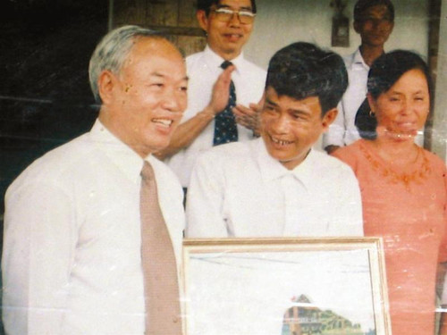 Chủ tịch Quốc hội Nguyễn Văn An tặng anh Thiết bức tranh sơn mài năm 2003, khi về thăm trang trại Ảnh: Phong Cầm (chụp lại ảnh tư liệu)