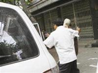 Công an đưa ông Nguyễn Văn Kiên - Chủ tịch HĐQT TCty Đầu tư và phát triển nhà Hà Nội ra xe. Ảnh: Hồng Vĩnh