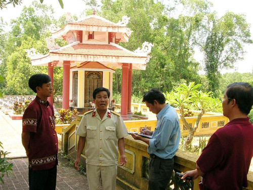 Anh Hồ Tất Ái (thứ 2 từ trái sang) đang kể chuyện về Nghĩa trang với khách đến viếng. Ảnh: Sáu Nghệ
