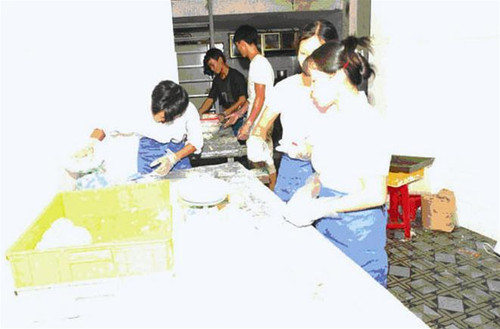 Phóng viên Tiền phong (trái) và những thợ làm bánh chỉ phải đeo tạp dề, găng tay bằng nilon khi có đoàn kiểm tra đến Ảnh: CTV