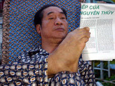 Sáng nào, thầy Ký cũng dùng ngón chân kẹp báo đọc như thế này. Ảnh: Lao Động.