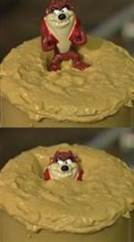 Một đồ chơi bằng nhựa, giống như một người, không đủ đặc để chìm hoàn toàn vào khối cát lún.