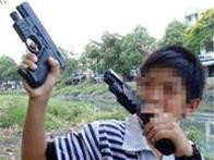 Một chú bé tập làm “sát thủ”, bắn súng hai tay! Chơi súng, liệu điều gì sẽ xảy ra? (ảnh chụp bên bờ kênh Nhiêu Lộc, TP.HCM chiều 13-2) - Ảnh: N.C.T.