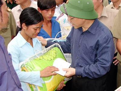 Chủ tịch QH Nguyễn Phú Trọng trao quà ủng hộ những gia đình thiệt hại do mưa lũ tại thôn Tùng Chỉn 1 Ảnh: baolaocai.vn