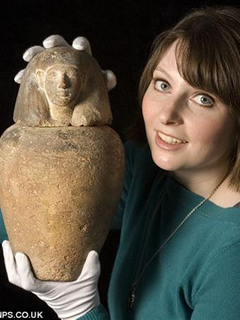 Người phụ trách đấu giá đang giới thiệu chiếc lọ cổ.