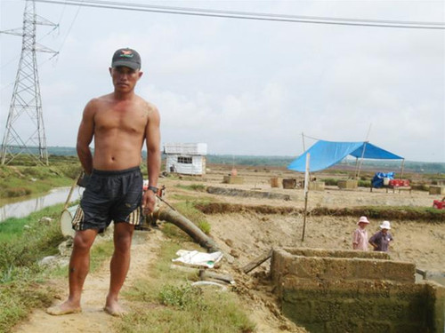 Anh Lê Tích Nam đứng chết lặng bên hồ tôm của mình Ảnh: H.T