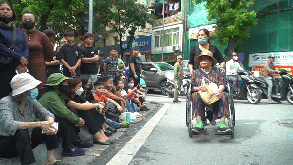 Dù tuổi cao, sức yếu không thể đi lại bình thường, bà Nguyễn Thị Lan (quê Hà Tĩnh) nhờ con cháu đưa đến nhà tang lễ để viếng Tổng Bí thư Nguyễn Phú Trọng. Khi con cháu ngỏ ý đưa về nhà người quen ở gần đó nghỉ ngơi, chờ sắp xếp vào viếng, bà Lan không đồng ý. Tay ôm hộp cơm chuẩn bị sẵn, bà nói sẽ xếp hàng chờ đến khi được vào viếng Tổng Bí thư Nguyễn Phú Trọng.