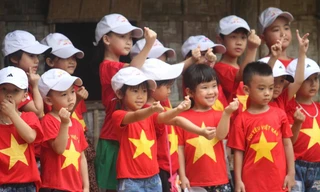 Trẻ em mặc áo đỏ sao vàng thả tim tại làng Sen quê Bác