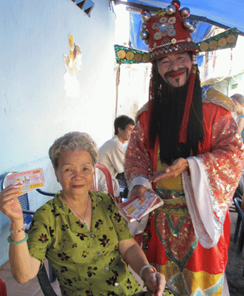 “Thần tài” với râu ria, hia mão, quần áo chỉnh tề… đi bán vé số dạo, ông luôn vui vẻ, tươi cười. Ảnh: CA TP.HCM . “Thần tài” với râu ria, hia mão, quần áo chỉnh tề… đi bán vé số dạo, ông luôn vui vẻ, tươi cười. Ảnh: CA TP.HCM