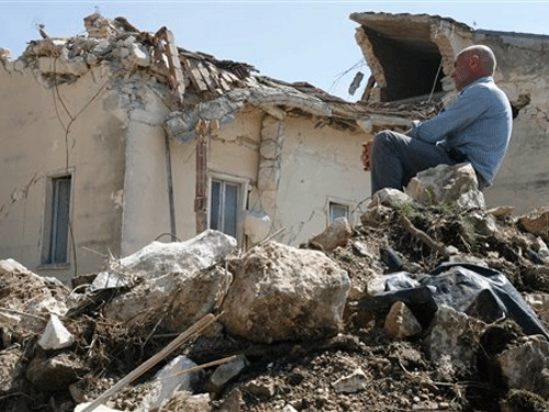 Một người dân L'Aquila ngồi ngay trên đống hoang tàn của ngôi nhà sau trận động đất. Ảnh: AP. Một người dân L'Aquila ngồi ngay trên đống hoang tàn của ngôi nhà sau trận động đất. Ảnh: AP