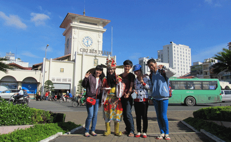 "Thần tài" chụp ảnh với các bạn trẻ trước chợ Bến Thành. Ảnh: CA TP.HCM . "Thần tài" chụp ảnh với các bạn trẻ trước chợ Bến Thành. Ảnh: CA TP.HCM .