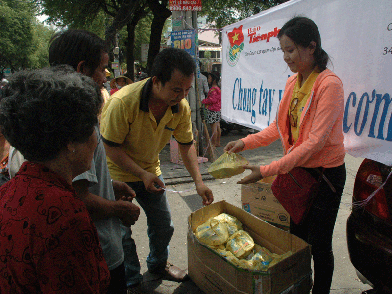 Các bạn Minh Tuấn, Trường Vi trao cơm cho người bệnh. Các bạn Minh Tuấn, Trường Vi trao cơm cho người bệnh