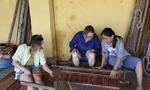 Du khách tập dệt chiếu dưới sự hướng dẫn của chị CôngẢnh: Giang Thanh