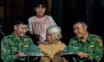 Hai người lính trẻ chụp ảnh lưu niệm, chia tay gia đình cụ Ngô Thị Lỡ với những chiếc mũ cối dính xi măng, có chiếc đứt dây Ảnh: Lê Văn Chương 
