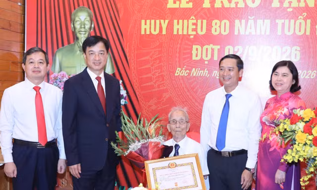 Ủy viên Bộ Chính trị, Bí thư Trung ương Đảng, Trưởng Ban Tổ chức Trung ương Nguyễn Duy Ngọc trao Huy hiệu 80 năm tuổi Đảng cho đảng viên Nguyễn Thanh Mậu.