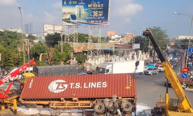 Xe container bất ngờ lật ở vòng xoay, sơn đổ trắng mặt đường lúc rạng sáng