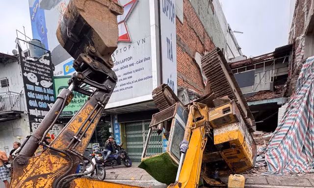 Đang tháo dỡ nhà, xe múc bất ngờ lật ngửa trên đường