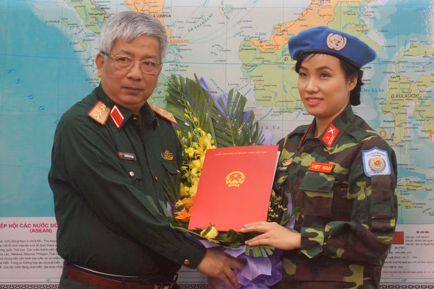 Thượng tướng Nguyễn Chí Vịnh trao quyết định của Chủ tịch nước cho thiếu tá Đỗ Thị Hằng Nga. Ảnh: Nguyễn Minh