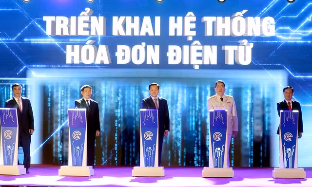 Phó Thủ tướng Lê Minh Khái, Bộ trưởng Tài chính Hồ Đức Phớc và các vị khách mời, lãnh đạo Tổng cục Thuế nhấn nút triển khai hệ thống hóa đơn điện tử giai đoạn 1. Ảnh: Phạm Thanh.