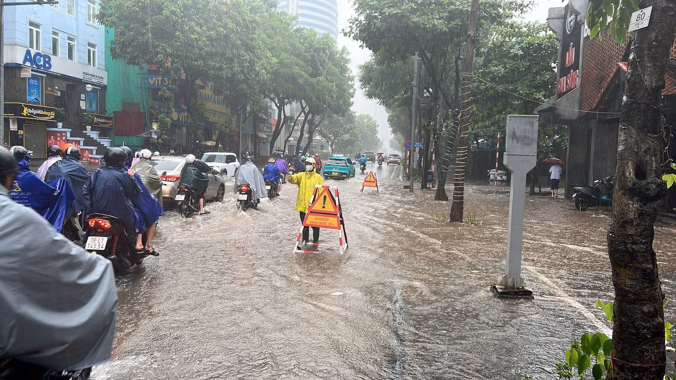 Lực lượng công nhân thoát nước ứng trực, liên tục vớt rác và khơi thông các hố thu nước tại điểm ngập sáng 17/9.