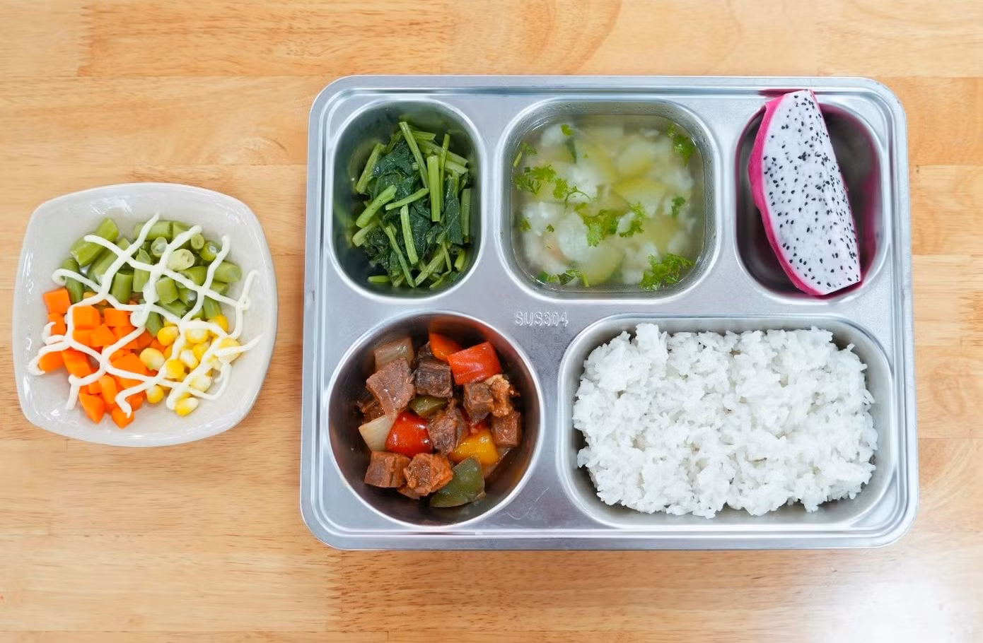 Bữa cơm trưa tại trường của học sinh tiểu học được xây dựng đa dạng, đủ chất và cân bằng dinh dưỡng theo Dự án Bữa ăn học đường.