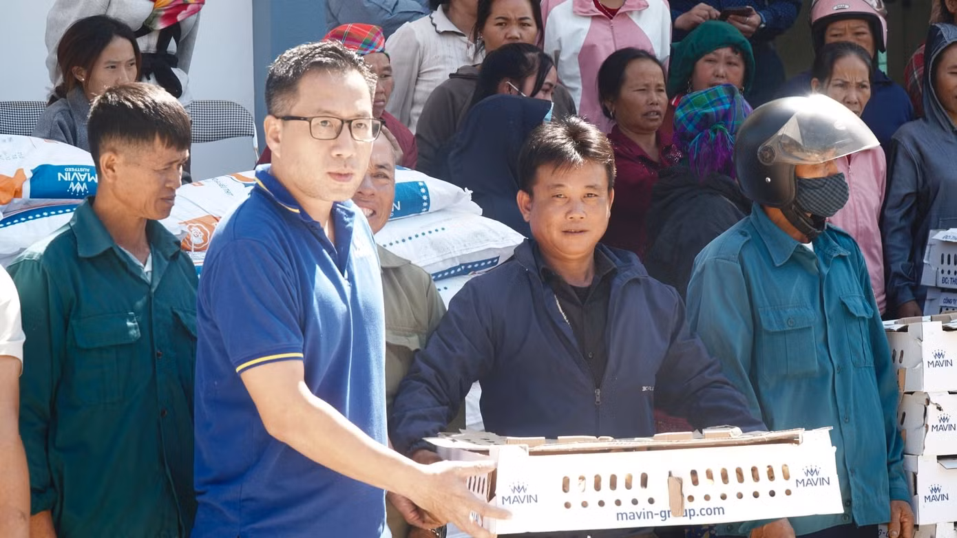 Ông Nguyễn Anh Tuấn - Phó Tổng Giám đốc Tập đoàn Mavin (áo xanh đậm) trực tiếp trao từng thùng gà cho người dân. Ảnh: Đức Bình.