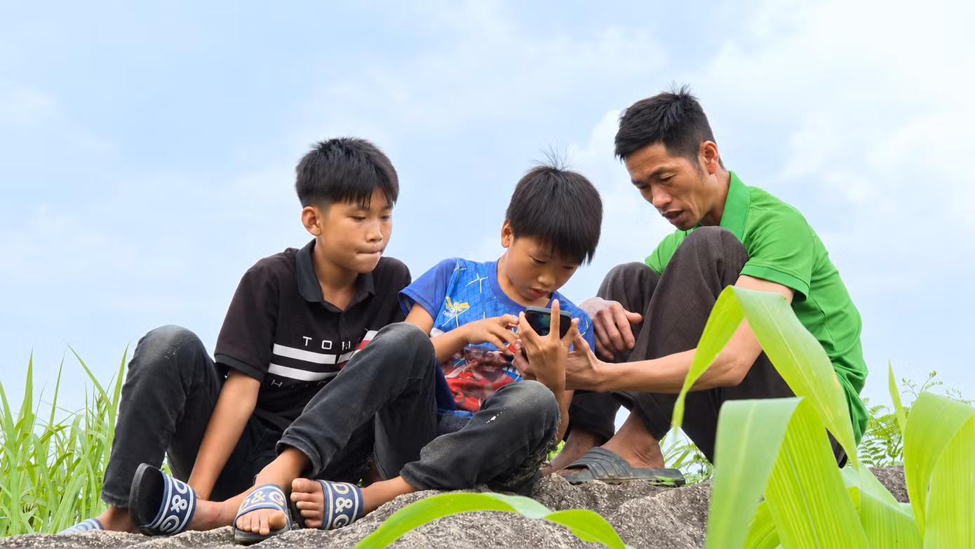 Ông Và nhờ cháu trai (áo xanh) hướng dẫn gọi điện cho con trai