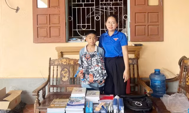 Em Bùi Khánh Duy tiếp nhận sách vở và đồ dùng học tập do Công ty Cổ phần Tiền Phong trao tặng.