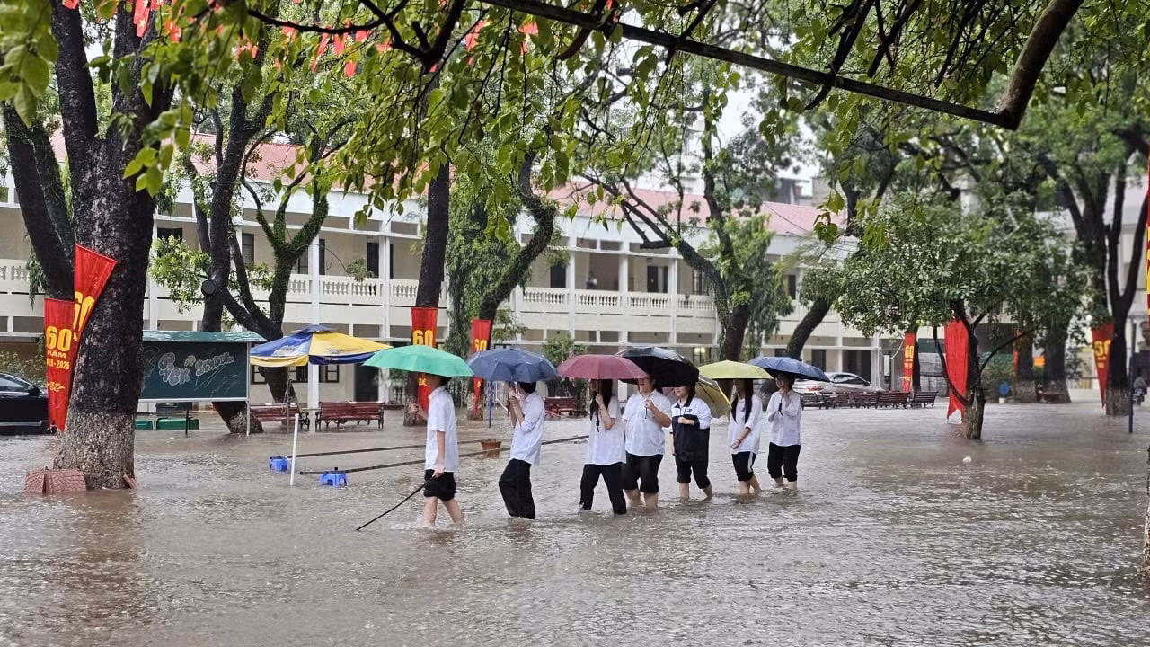 Học sinh một trường học ở Hà Nội ra về trong mưa ngập. Ảnh: NVCC.
