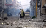 Một phụ nữ Palestine khi đi trên con phố tan hoang gần tháp Watan, nơi bị phá hủy sau đợt tấn công trả đũa của Israel ngày 8/10. (Ảnh: Reuters)