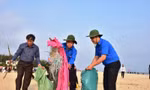 Chủ tịch Phan Ngọc Thọ (giữa) hăn hái gom nhặt rác, góp phần làm sạch môi trường bãi tắm Thuận An