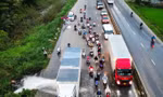Tài xế nhận 'mưa lời khen' khi điều khiển xe container chắn dòng nước cho xe máy đi qua
