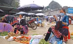 Khi chợ vắng khách, phụ nữ Mông tranh thủ thêu váy áo Ảnh: LỘC LIÊN