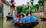 Người dân vùng lũ Chương Mỹ chèo thuyền nhận đồ hỗ trợ 