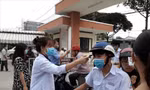 Học sinh trường THPT chuyên Nguyễn Hữu Huân được đo thân nhiệt trước khi vào lớp