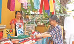 Chị Trương Nguyễn Hoài An, người sáng lập Chợ phiên thủ công (bên phải) hỗ trợ các cư dân của xóm bày biện, sắp xếp hàng hóa Ảnh: Giang Thanh 