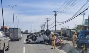 Ô tô chở 4 người lật ngửa trên dốc cầu Bình Thuận