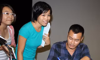 Nguyễn Thế Hoàng Linh ký tặng thơ độc giả tối 20-9. Ảnh: Cúc Chi