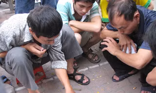 Con trong phòng thi làm bài, bố ở ngoài đánh bạc