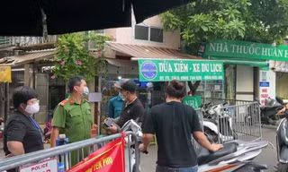 Cặp vợ chồng đôi co với người ở chốt kiểm soát dịch chợ Yên Phụ.