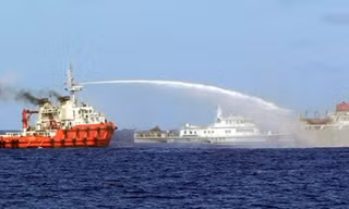 Một tàu Trung Quốc (trái) phun vòi rồng vào tàu Việt Nam (phải) trong khi tàu Canh gác bờ biển Trung Quốc chạy ở bên trên Biển Đông ngày hôm qua (7/5). 