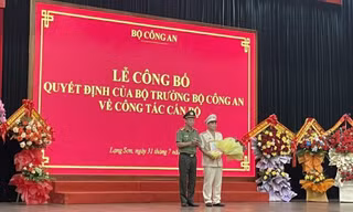 Thượng tá Nguyễn Quang Huyên (bìa phải) nhận Quyết định, hoa chúc mừng. Ảnh: Duy Chiến 
