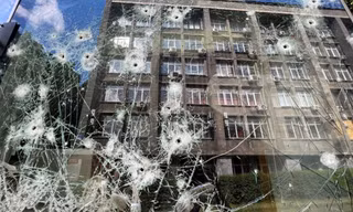 Cửa sổ một cửa hàng bị thủng lỗ chỗ ở Kharkiv ngày 23/5. (Ảnh: Reuters)