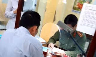 Cán bộ phòng QLXNC Hải Dương "báo giá" người dân làm hộ chiếu nhanh.ảnh: DH
