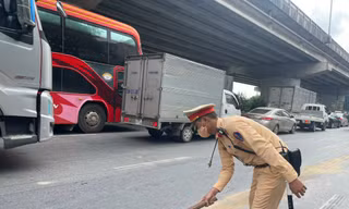 Cán bộ, chiến sỹ Đội CSGT đường bộ số 7 xử lý vết dầu loang tránh nguy hiểm cho người tham gia giao thông