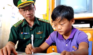 Cán bộ Đồn Biên phòng Cửa khẩu Trà Lĩnh đến nhà kèm cặp em Hoàng Văn Truyền học bài.