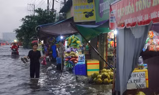 Mưa trắng trời, người dân TPHCM xách dép lội bì bõm trên quốc lộ