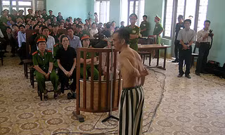 Ông Huỳnh Văn Nén cởi áo, chỉ những vết sẹo mà ông nói là do bị đánh trong tù, tại phiên tòa phúc thẩm (lần 3) “Vụ án vườn điều” ngày 9/3/2005. Ảnh: Nguyễn Đình Quân 