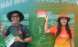 Runner háo hức check-in bảng tên dưới mưa, sẵn sàng chinh phục Tiền Phong Marathon 2025